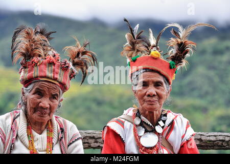 Banaue, Philippines-October 8, 2016: Einige ältere Ifugaos - Männer und Frauen - noch Kleid in ihrer traditionellen Kleidung und Kopfbedeckung während der Sitzung durch die r Stockfoto