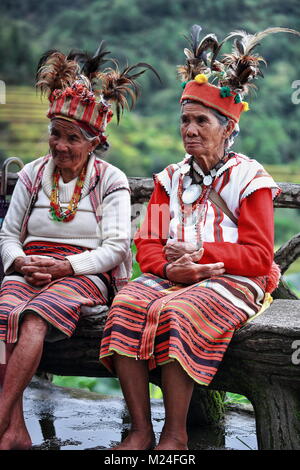 Banaue, Philippines-October 8, 2016: Einige ältere Ifugaos - Männer und Frauen - noch Kleid in ihrer traditionellen Kleidung und Kopfbedeckung während der Sitzung durch die r Stockfoto