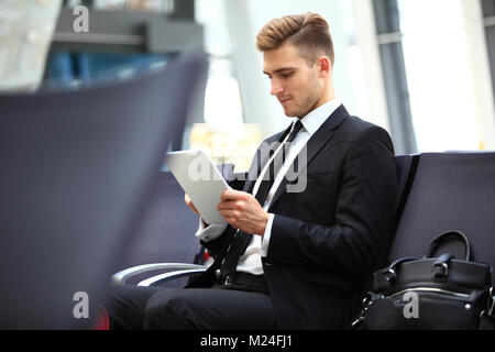 Geschäftsmann mit Digital-Tablette In Flughafen-Abflug-Lounge Stockfoto