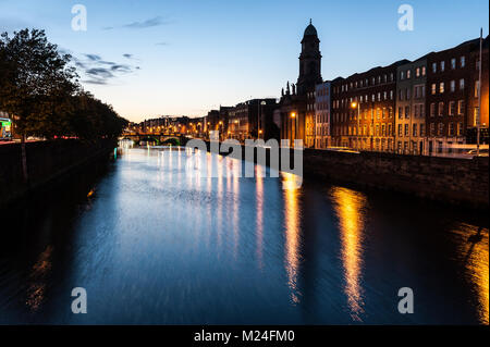 Dublin City bei Sonnenuntergang mit Blick auf den Fluss Liffey und die historischen Grattan Brücke in der Ferne. Lange Belichtung. Dublin Irland Stockfoto