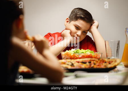 Mutter mit Salat statt Pizza zu Übergewicht Sohn Stockfoto