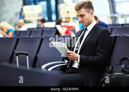 Geschäftsmann mit Digital-Tablette In Flughafen-Abflug-Lounge Stockfoto