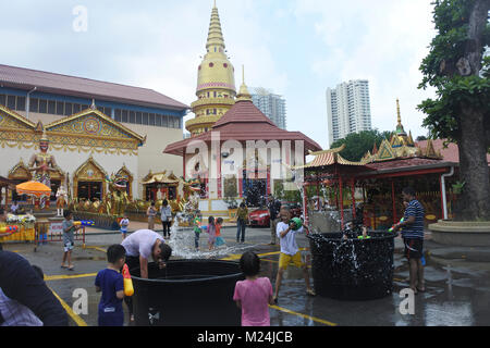 Die Leute an der Songkran Festival werfen Wasser in Eimern an einander von einem Alrge Tank mit Wasser, Wasser in Bewegung ist eingefroren Stockfoto