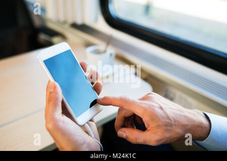 Reifen Geschäftsmann mit Smartphone, der mit dem Zug reist. Stockfoto