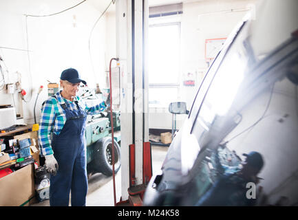 Portrait eines älteren weiblichen Mechaniker in der Garage. Stockfoto