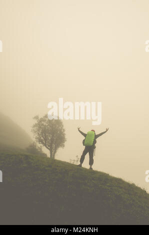 Frauen Reisenden auf Berggipfel geniessen Luftaufnahme hob die Hand über den Wolken Reisen Lifestyle erfolg konzept Abenteuer aktiv Urlaub im Freien Stockfoto
