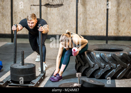 Man Schlitten schieben in der Turnhalle Stockfoto