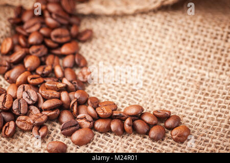 Erhöhten Blick auf gerösteten Kaffeebohnen auf grobe Jute Tuch. Stockfoto