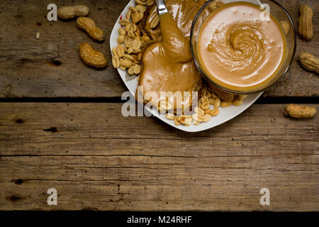 Peanut butter Sandwiches mit Zutaten auf Holztisch. Stockfoto