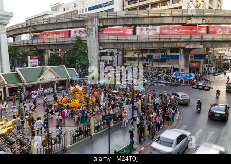 Blick auf eine Menge Leute am Erawan Schrein, belebten Straßen und BTS Skytrain auf einer erhöhten Brücke in Bangkok, Thailand. Stockfoto