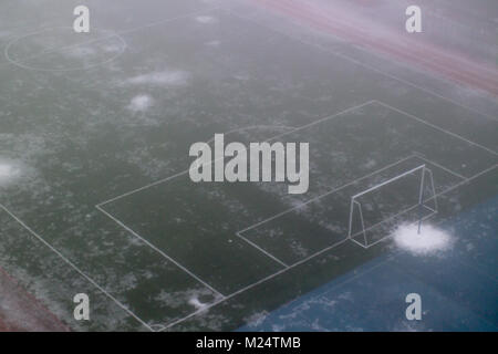 Fußballtor im Nebel in der Schule Stadion. Schneeschmelze Stockfoto