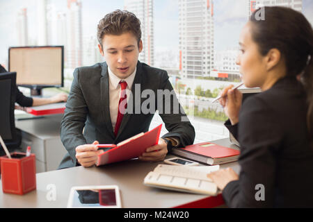 Portrait der junge Unternehmer im Gespräch mit Kollegen diskutieren Arbeit während der Tagung in Immobilien Agentur Stockfoto