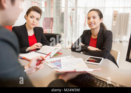Drei Personen im Kreis sitzen am runden Tisch und diskutieren arbeiten, konzentrieren sich auf zwei schöne Geschäftsfrau hören Chef Stockfoto