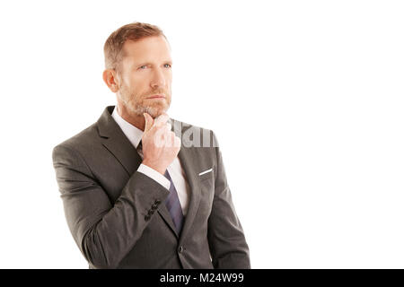 Im mittleren Alter Geschäftsmann tragen Anzug bei isolierten weißen Hintergrund stehen und nachdenklich. Stockfoto