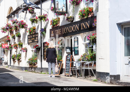 Blonde Frau auf dem Weg zur London Inn Pub in Padstow, Cornwall, England, Großbritannien. Stockfoto