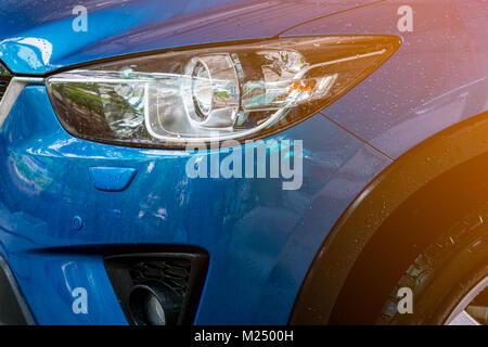 Blaue kompakte SUV-Auto mit Sport und modernes Design sind Waschen mit Wasser. Car Care Service Business Konzept. Auto bedeckt mit Tropfen Wasser nach Cle Stockfoto