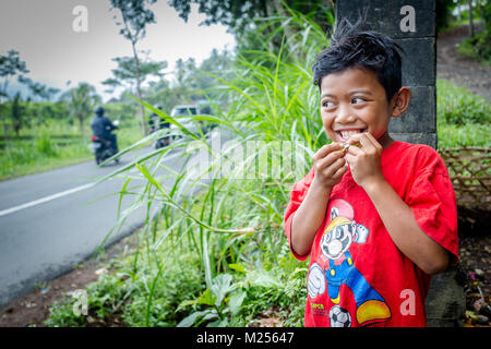 Bali, Indonesien - 30. August 2013: Closeup Portrait von cute Asian balinesischer Junge im Freien. Ubud, Bali Insel, lächelndes Kind Stockfoto