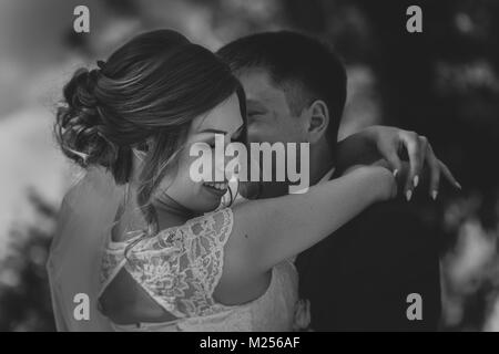 Schwarz Weiß Foto paar Bräutigam und Braut auf dem Hintergrund Blätter Stockfoto