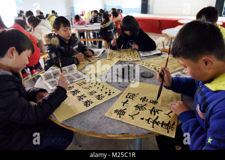 (180205) - NANFENG, Februar 5, 2018 (Xinhua) - die Schüler und Schülerinnen lernen, Pinsel Kalligraphie zu einem Charity Schule in Hangshan Dorf, Taihe Township, nanfeng County, im Osten der chinesischen Provinz Jiangxi, Feb 5, 2018. Hangshan Dorf befindet sich in einer abgelegenen Gegend in der Region. Wie viele Eltern hier Startseite zur Arbeit gehe, viele Kinder hatten, zu Hause zu bleiben. Xi Weixing, eine lokale Dorfbewohner, die in der Provinz Guangdong begonnen, baut eine Nächstenliebe, die Schule hier, kostenlos nach - Schule Kurse plus Mittagessen für die zurückgelassenen Kinder, deren Eltern arbeiten in der Regel als Wanderarbeiter in anderen Städten. Die Schule ist Stockfoto