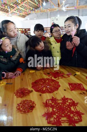 (180205) - NANFENG, Februar 5, 2018 (Xinhua) - Kinder lernen Scherenschnitte zu einem Charity Schule in Hangshan Dorf, Taihe Township, nanfeng County, im Osten der chinesischen Provinz Jiangxi, Feb 5, 2018. Hangshan Dorf befindet sich in einer abgelegenen Gegend in der Region. Wie viele Eltern hier Startseite zur Arbeit gehe, viele Kinder hatten, zu Hause zu bleiben. Xi Weixing, eine lokale Dorfbewohner, die in der Provinz Guangdong begonnen, baut eine Nächstenliebe, die Schule hier, kostenlos nach - Schule Kurse plus Mittagessen für die zurückgelassenen Kinder, deren Eltern arbeiten in der Regel als Wanderarbeiter in anderen Städten. Die Schule wird Ope Stockfoto