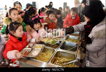 (180205) - NANFENG, Februar 5, 2018 (Xinhua) - Kinder erhalten kostenlose Mahlzeiten zu einem Charity Schule in Hangshan Dorf, Taihe Township, nanfeng County, im Osten der chinesischen Provinz Jiangxi, Feb 5, 2018. Hangshan Dorf befindet sich in einer abgelegenen Gegend in der Region. Wie viele Eltern hier Startseite zur Arbeit gehe, viele Kinder hatten, zu Hause zu bleiben. Xi Weixing, eine lokale Dorfbewohner, die in der Provinz Guangdong begonnen, baut eine Nächstenliebe, die Schule hier, kostenlos nach - Schule Kurse plus Mittagessen für die zurückgelassenen Kinder, deren Eltern arbeiten in der Regel als Wanderarbeiter in anderen Städten. Die Schule ist offen für c Stockfoto