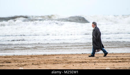 Gijon, Spanien. 05. Januar, 2018. Ein Mann geht auf den Strand San Lorenzo in Gijon, während eines Tages, der starken Brunnen auf dem Meer. Im Norden von Spanien ist in Alarm durch den Schnee, Regen, Flügel und Schwellen. © David Gato/Alamy leben Nachrichten Stockfoto