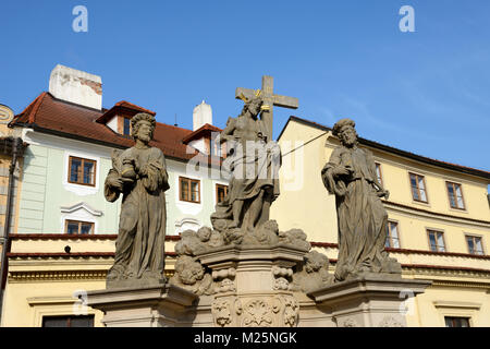 Statue des Heiligen Erlösers mit Cosmas und Damian im Winter Sonnenlicht auf der Karlsbrücke in Prag, Tschechische Republik. Stockfoto