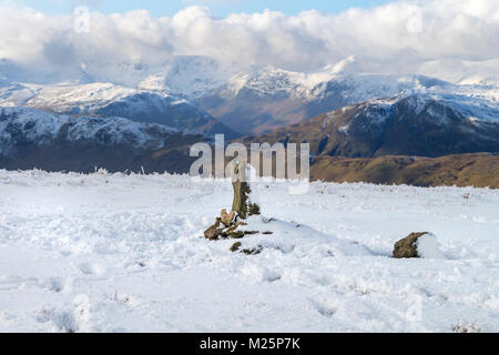 Ob auf dem Gipfel des Hügels im Winter, mit den Bergen der Helvellyn Bereich Jenseits, Lake District, Cumbria, UK. Stockfoto