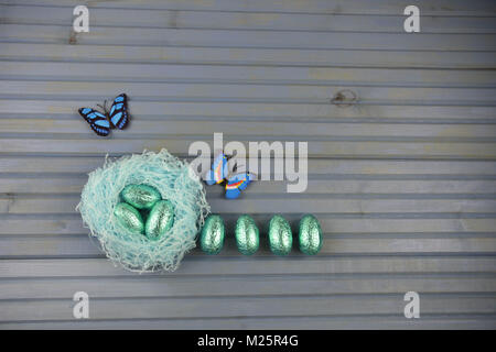 Ostern Dekorationen mit Nest von Schokolade Eier und Frühling Schmetterlinge Stockfoto