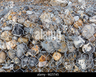 Meer Abwehr aus Drahtgeflecht Käfige mit großen Strand Kies Stockfoto