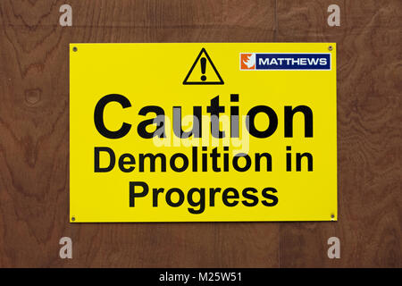 Vorsicht Abriss im Gange Warnschild, mit Ausrufezeichen und Logo der Demolition Company matthews Stockfoto