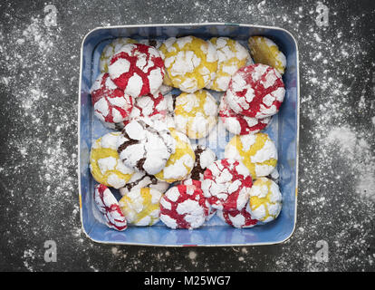 Hausgemachte Zitrone, Himbeere und Schokolade Crinkle Cookies in einer Dose auf schiefer Hintergrund Stockfoto