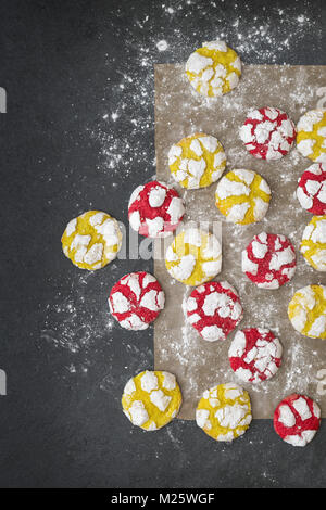 Hausgemachte Zitrone und Himbeere Crinkle Cookies auf ein Backblech auf schiefer Hintergrund Stockfoto