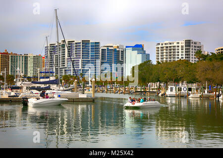 Boote in den Hafen mit der Waterfront Apartments mit Blick auf den Yachthafen in Sarasota, FL, USA Stockfoto