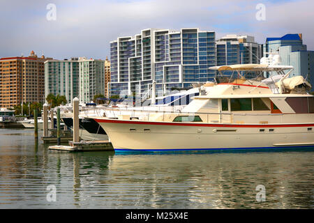 Boote in den Hafen mit der Waterfront Apartments mit Blick auf den Yachthafen in Sarasota, FL, USA Stockfoto