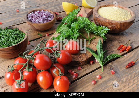 Rohstoffe und Zutaten für tabbouleh Salat auf rustikalen Holztisch Stockfoto