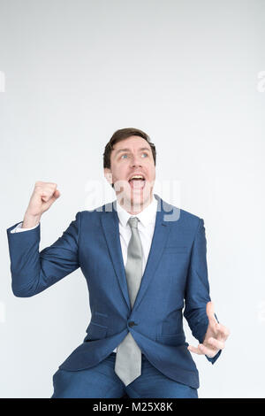 Ein sehr aufgeregt, gut gekleideter Mann im Anzug stanzen die Luft in Triumph an eine Ausführung. portrait isoliert auf weißem Hintergrund Stockfoto