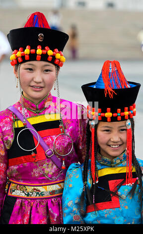 Zwei Mädchen in traditionellen deel Kostüm und den typischen Hut mit, dass die konische Spitze, Nationaltracht Festival, Ulaanbaatar, Mongolei Stockfoto