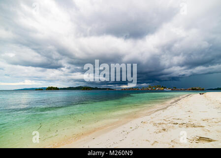 Tropischen Strand, Karibik, glasklares türkisfarbenes Wasser, remote Togean Inseln (togian Inseln), Sulawesi, Indonesien. Dramatische Himmel bei Sonnenuntergang. Stockfoto