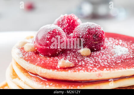 Pfannkuchen hausgemachte Kuchen mit Beeren gefroren Kirsche mit Puderzucker bestreut und Pinienkernen auf weißen Teller dekoriert Stapel Stockfoto