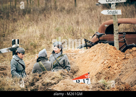 Gomel, Belarus - November 26, 2016: Schöne Mädchen von der Einweisende in der Uniform der Deutschen Zeiten des Großen Vaterländischen Krieges in den Schützengräben. Re Stockfoto