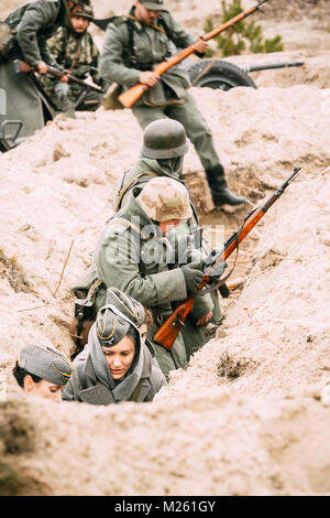 Gomel, Belarus - November 26, 2017: Ein deutscher Soldat in einem Graben mit einem Gewehr. Soldaten der Verteidigung besetzen. Wiederaufbau Stockfoto