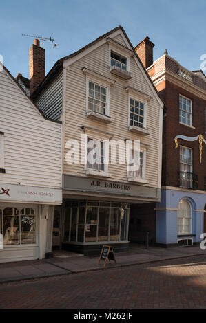 J R Friseure Salon, ein altes Holz gerahmt High Street Gebäude, das sich bewegt und schiefen über Anfahren aus der Eigenschaft, muss wieder binden Stockfoto