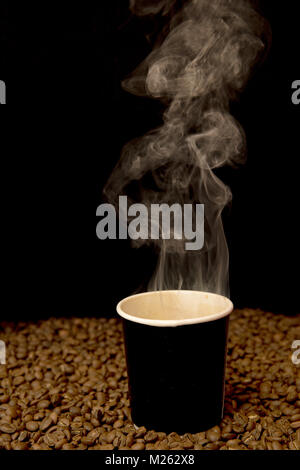 Eine Tasse Kaffee mit Kaffeebohnen umgeben Stockfoto