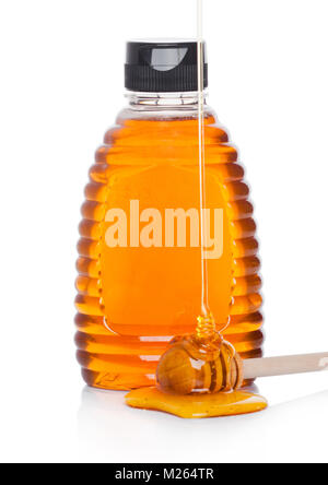 Kunststoff Glas Flasche mit organischen Natürlicher Honig mit Stock und flüssigen Honig auf weißem Hintergrund Stockfoto