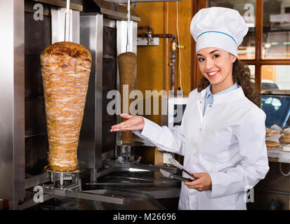 Professionelle lächelnd weibliche Kochen mit gegrilltem Fleisch am Spieß für Kebab Stockfoto
