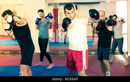 Sportler üben Boxsport Schläge in die Boxing Hall Stockfoto