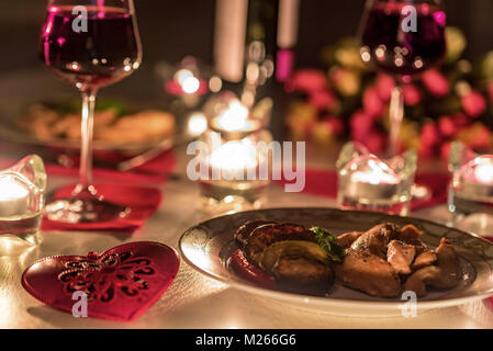 Romantisches Abendessen für Zwei mit Wein, Kerzen, Blumen Stockfoto