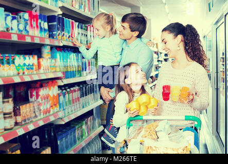 Gerne gewöhnliche Kunden mit Kindern Auswahl süße Milchprodukte im SB-Warenhaus. Stockfoto