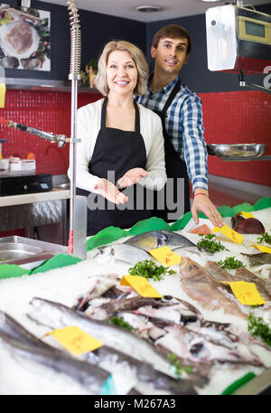 Lächelnd Shop Verkauf von Sachen auf Eis gekühlt Fisch im Supermarkt Stockfoto